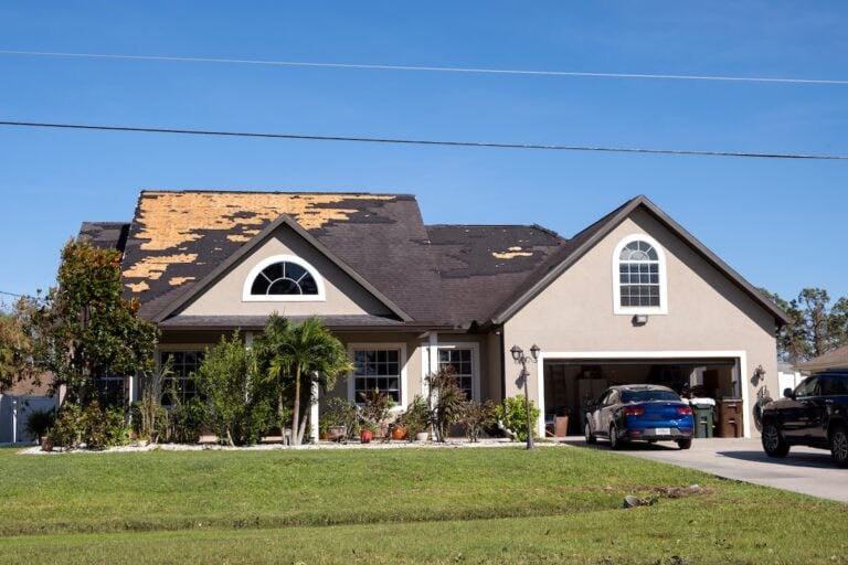 Damaged house roof with missing shingles after hurricane Ian in Florida. Consequences of natural disaster.